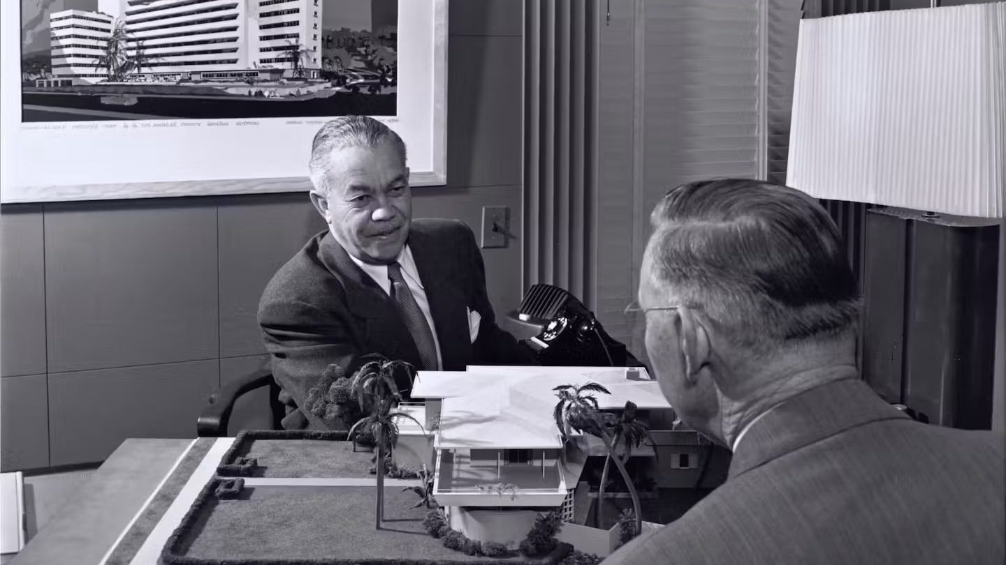 Architect Paul R. Williams sitting across the table from a client in 1952. Photo by Julius Shulman, courtesy of © J. Paul Getty Trust, Getty Research Institute, Los Angeles.